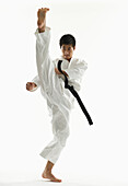 Asian male karate black belt kicking in air, Jersey City, NJ, USA