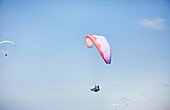 Person paragliding against blue sky, Sacramento, San Diego, USA