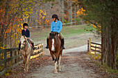 Caucasian girl and trainer riding horses, Manakin, VA, Goochland