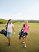 Women carrying golf bags on golf course, Mission Viejo, California, USA