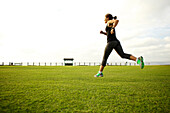 Mixed race woman running in park field, San Diego, California, United States
