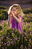 Caucasian girl smelling flowers, Lehi, Utah, USA
