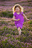 Caucasian girl running through field of flowers, Lehi, Utah, USA