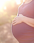 Pregnant Caucasian woman caressing stomach, Manhattan Beach, California, United States