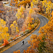 Caucasian woman running along autumn road, Alpine, Utah, USA