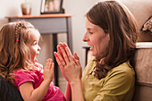 Caucasian mother and daughter playing clapping game, Lehi, Utah, USA