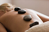 Caucasian woman receiving hot stone massage, Saint Louis, MO, USA