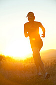 Caucasian woman running at sunset, Bainbridge Island, WA, USA