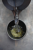 Water being poured on tea leaves, Santa Fe, New Mexico, USA