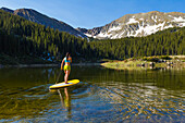 Hispanic woman riding paddle board, Taos, New Mexico, USA