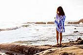 Japanese woman standing on beach, San Diego, CA, USA
