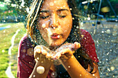 Hispanic teenage girl playing with glitter outdoors, Austin, Texas, US