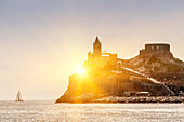 Sun rising over castle on island, Portovenere, Liguria, La Spezia, Italy, Portovenere, Liguria, La Spezia