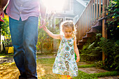 Father and daughter walking in backyard, Portland, OR, USA