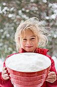 Caucasian girl holding bowl in snow, Santa Fe, New Mexico, USA