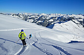 Two female back-country skiers downhill skiing from mount Steinberg, Kitzbuehel Alps, Tyrol, Austria