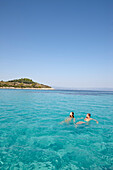 Paar schwimmt in der Blue Lagoon, Vourvourou, Sithonia, Chalkidiki, Griechenland