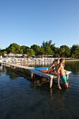 Couple on a pier at a hotel beach, Vourvourou, Sithonia, Chalkidiki, Greece