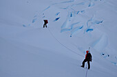 Two mountaineers passing a glacier, Monte Sarmiento, Cordillera Darwin, Tierra del Fuego, Chile