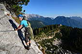 Frau klettert Constantini-Klettersteig, Rifugio Carestiato im Hintergrund, Cima Moiazza, Dolomiten, Venetien, Italien