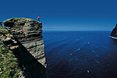 Climber on top of Old Man of Hoy, Hoy, Orkney Islands, Scotland, Great Britain