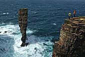 Hikers looking at North Gaulton Castle, West Mainland, Orkney Islands, Scotland, Great Britain