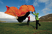 Two hikers pitching up a tent by Loch Crabhadail, Harris, Lewis and Harris, Outer Hebrides, Scotland, Great Britain