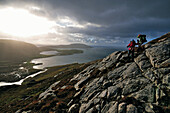 Hikers descending from Taran Mor to Loch Crabhadail, Harris, Lewis and Harris, Outer Hebrides, Scotland, Great Britain