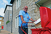 Postman in Poundbury, Dorchester, Dorset, England, Great Britain