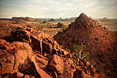 Blick in die Ferne aus zahlreiche Felshügel im Damara Land bei Sonnenuntergang, typische Landschaft, Damaraland, Namibia, Afrika