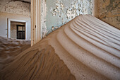 Sand dune burying the interior of a house in the deserted ghost town in the Diamond restricted area, Kolmanskop near Luderitz, Namibia, Africa