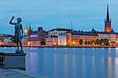 Bronze Statue Sangen im Stadthausgarten und Riddarholmen mit seinem markanten Kirchturm im Hintergrund, Stockholm, Schweden