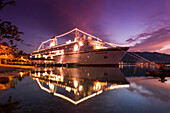 Illuminated cruiser in harbor at sunset, Port Antonio, Portland, Jamaica