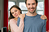 Portrait of young couple, woman with hands on mans shoulders