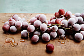 Frozen red grapes on wooden chopping board