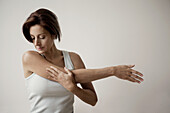 Mature woman stretching arm