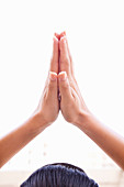 Nahaufnahme einer Frau, die ihre Hände in Gebetshaltung zusammenlegt
