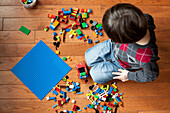 Boy with plastic blocks on floor