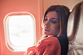 Female passenger asleep under blanket on aeroplane
