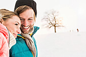 Woman with head on man's shoulder in snow