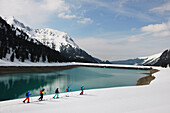 Skiers by lake and mountain, Kuhtai, Austria