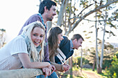 Group of four friends leaning on fence