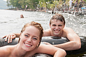 Young couple floating in inflatable rings
