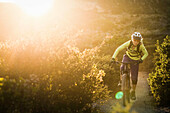 Young woman mountain biking on dirt track, Monterey, California, USA