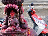 A motorcycle sits behind a Hindu shrine in Bungamati, Nepal.