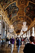 Tourists Walking through the Hall Of Mirros, Chateau Versaille, Ile de France, France.