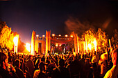 'A Crowd During An Outdoor Music Event With Fire Being Shot Up From Both Sides Of The Stage; California, United States Of America'