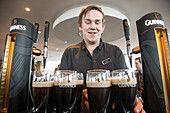 Serving dark draught ale at the old brewery, guinness storehouse, dublin, ireland