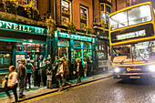 Nighttime ambiance on suffolk street in front of the pub o'neills bar, dublin, ireland