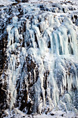 Kirkjufellsfos, frozen waterfall on kirkjufell mountain near grundarfjordur, snaefellsnes peninsula, western iceland, europe